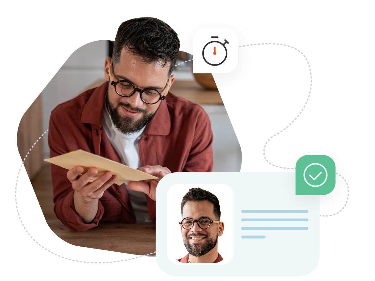 A man with glasses leaning againsta a table and inspecting a package he has received 