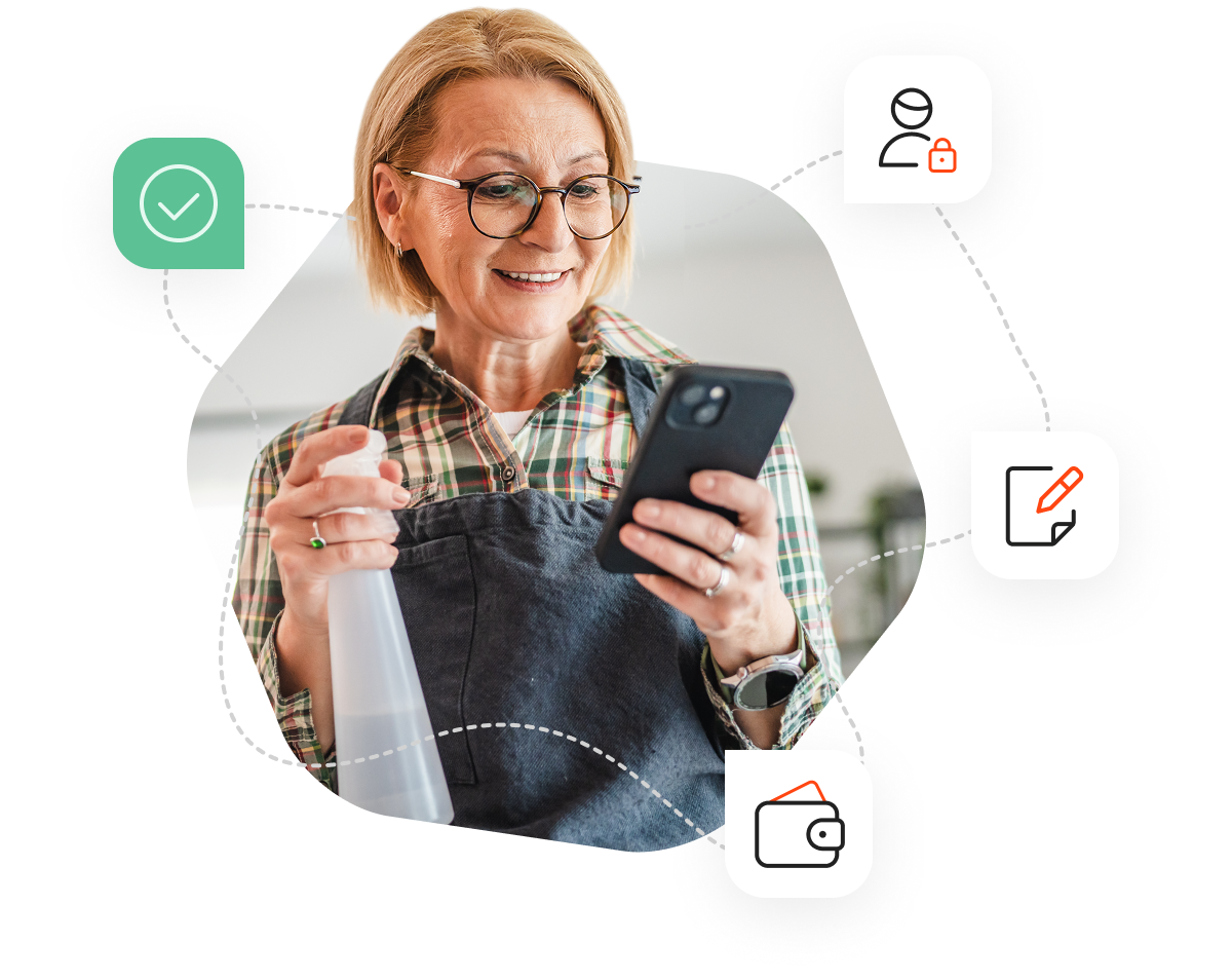 A woman with short hair and round glasses standing and looking at her phone