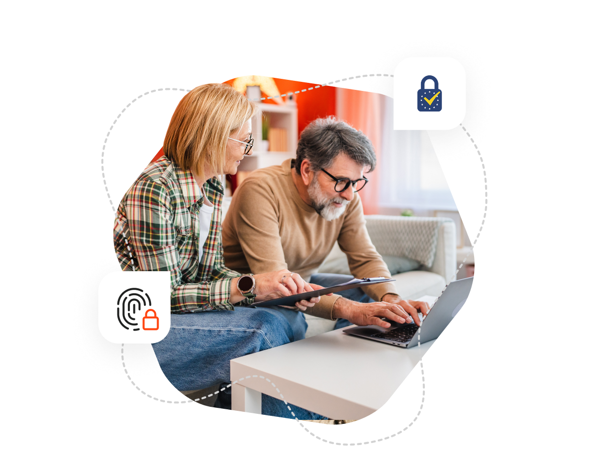 A man and a woman sitting on the sofa and looking at a laptp